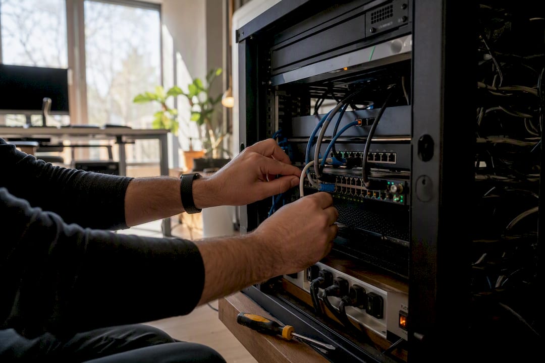 Hands connecting cables on server rack