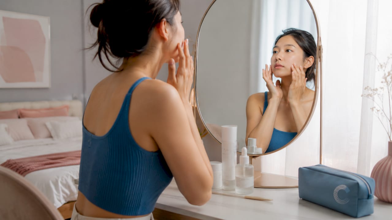 Woman applying hydrating serum in bathroom