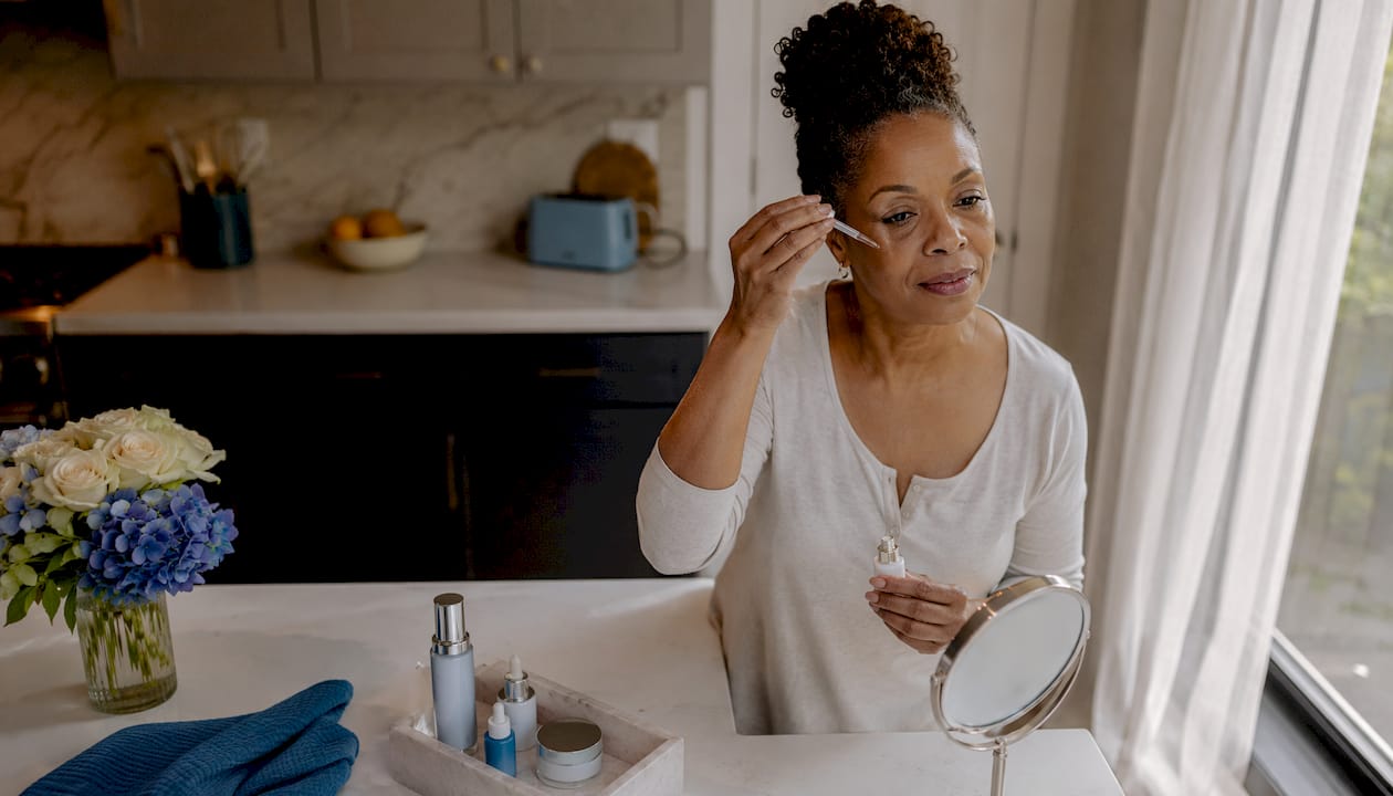 Woman applying anti-aging serum at home