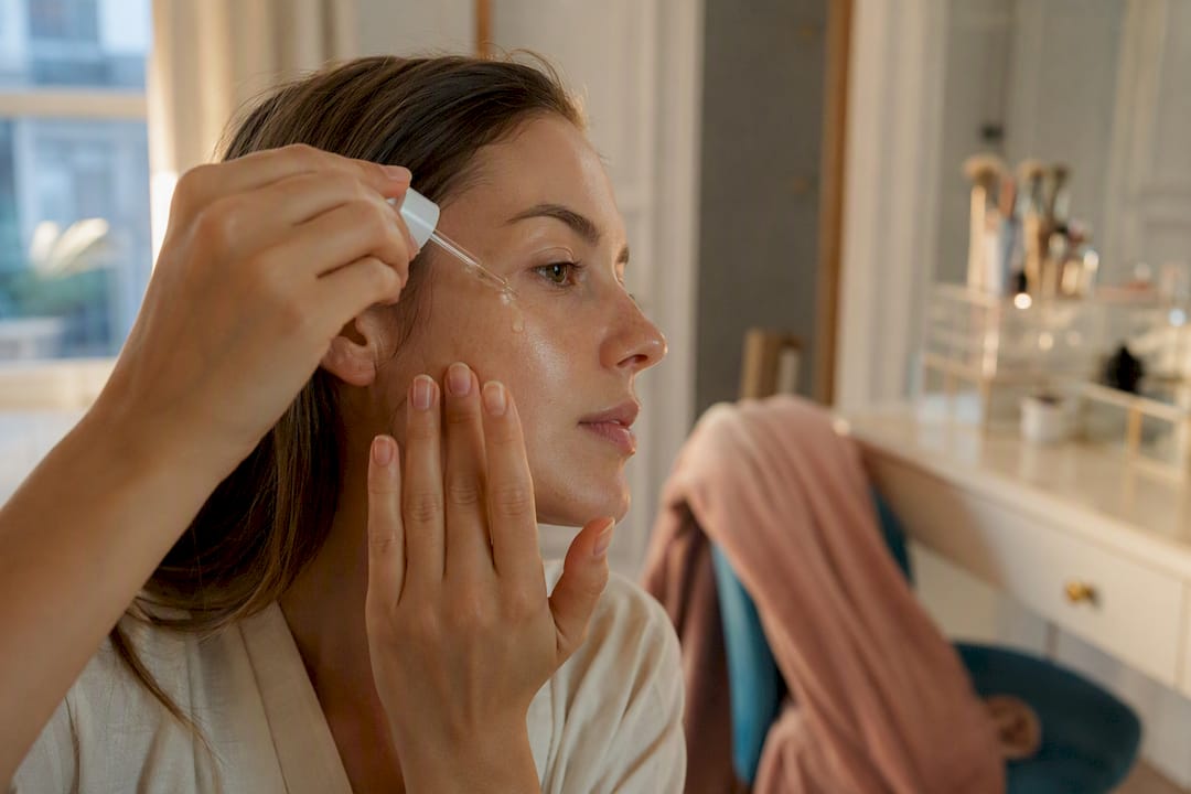 Close-up of applying facial oil on cheek