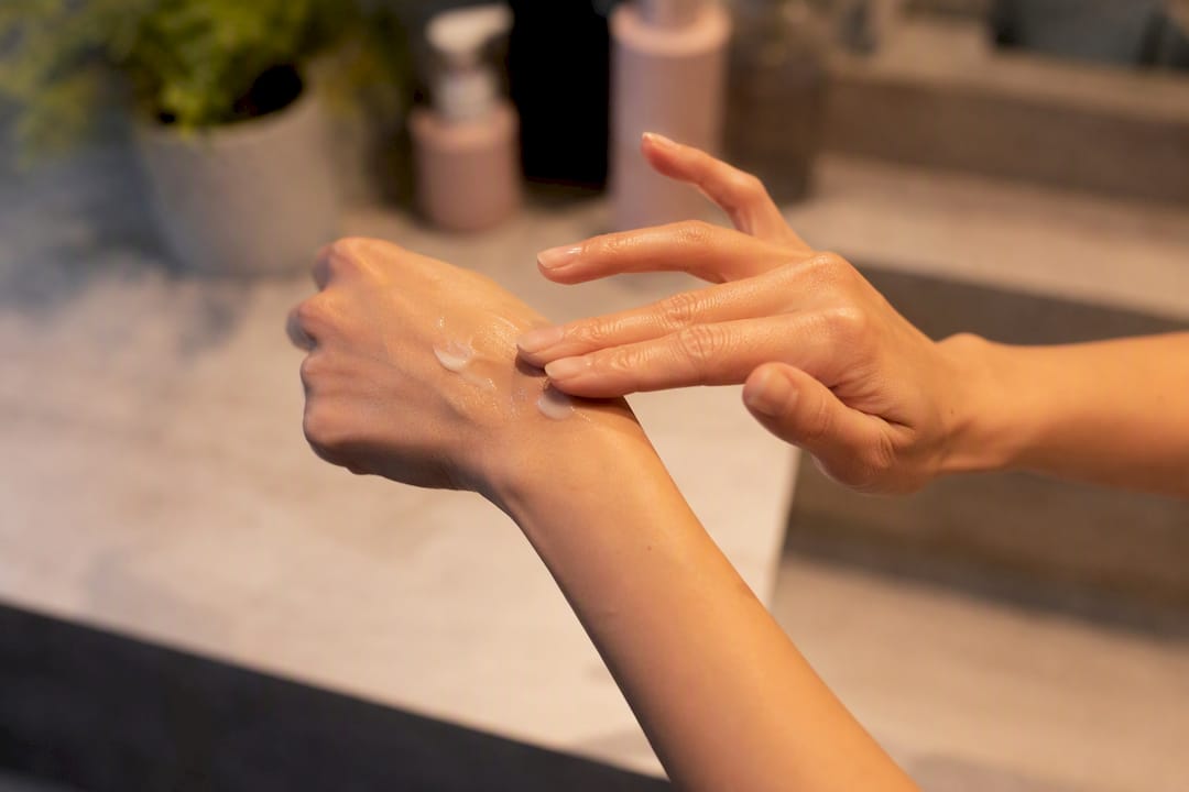 Hands layering moisturizer over retinol serum