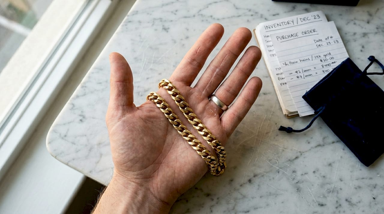 Gold curb chain resting in person's palm
