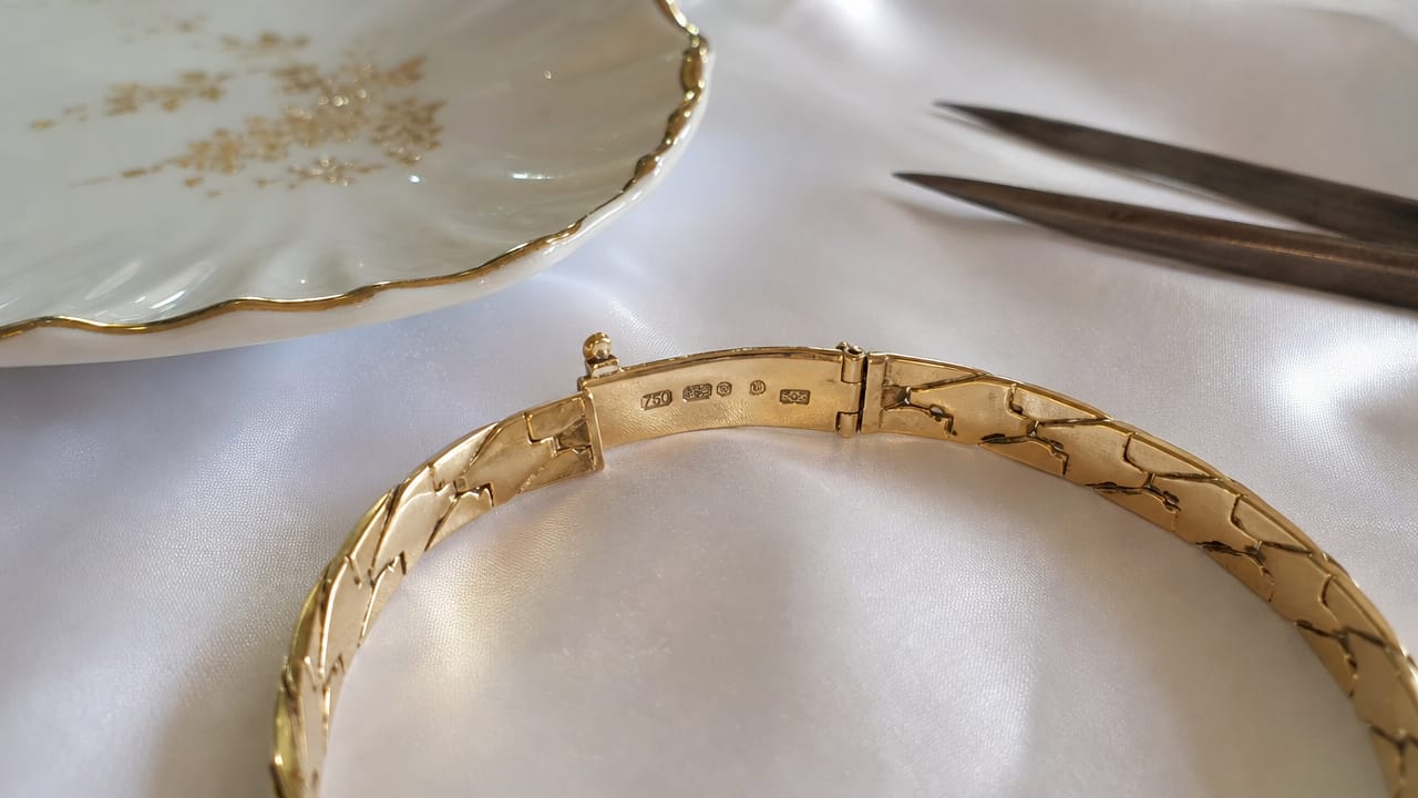 Close-up of hallmarks on gold bracelet clasp