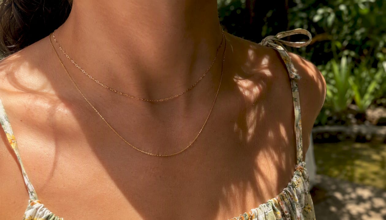 Delicate gold chains on summer bare skin