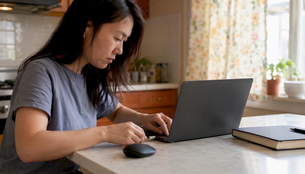 Woman using USB-C to USB-A adapter with laptop