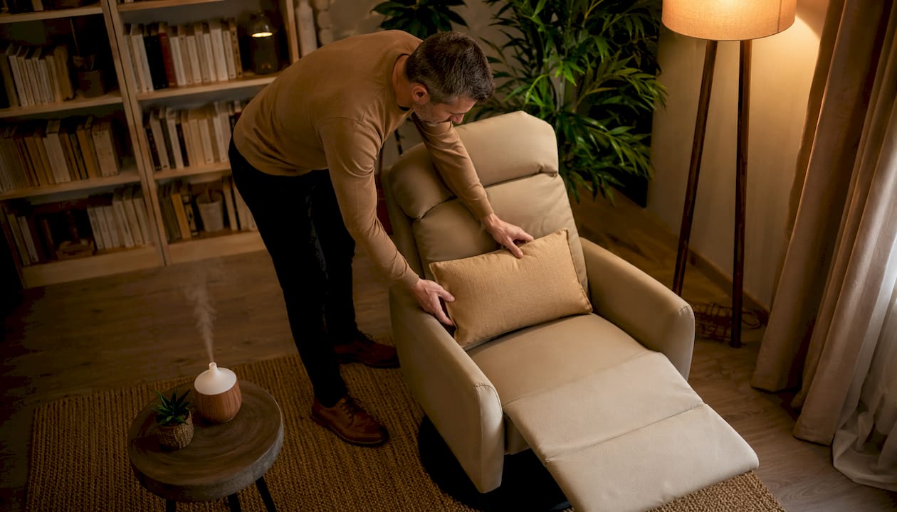 Un thérapeute prend le temps d’ajuster les coussins dans son cabinet de consultation dédié à l’hypnose, créant ainsi une atmosphère chaleureuse et accueillante pour ses patients.