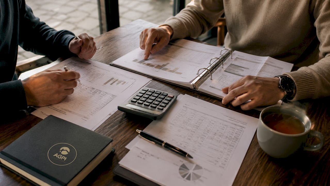 Des mains manipulant une calculatrice sur un bureau de travail