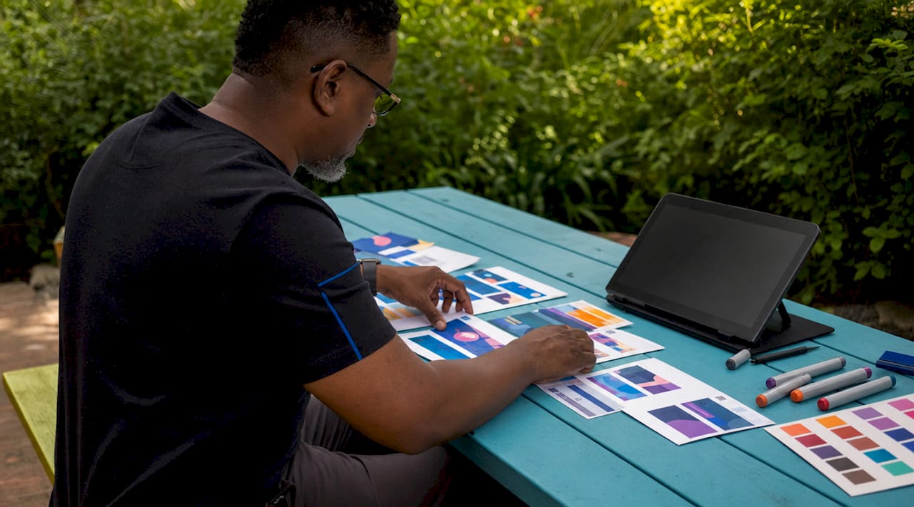 Hands arranging display ad mockups on desk