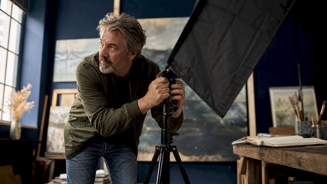 Photographer adjusting softbox angle in office setting