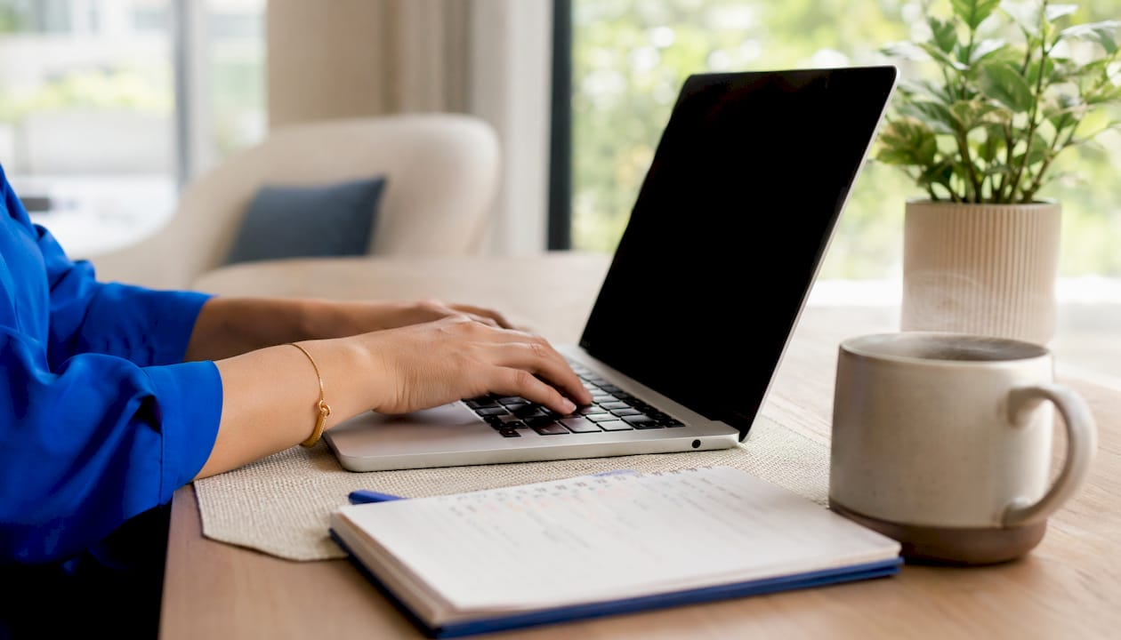 Hands typing SEO keyword data on laptop
