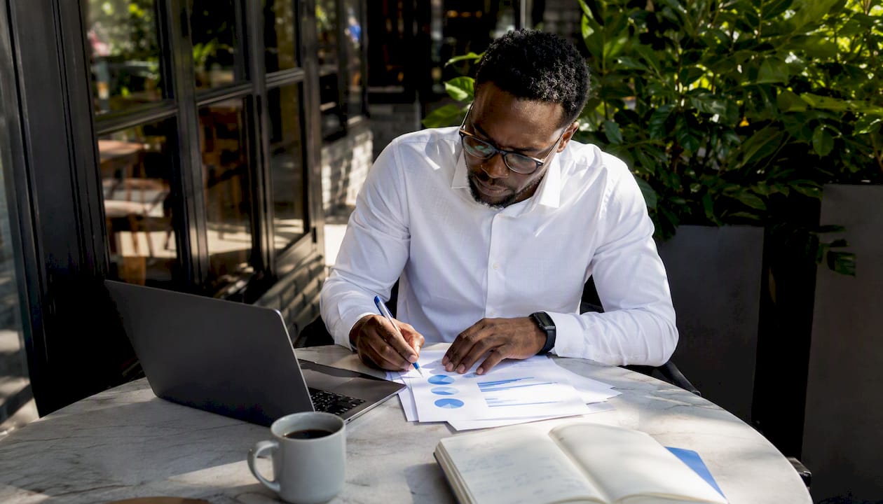 Man reviewing charts on AI benefits in home office