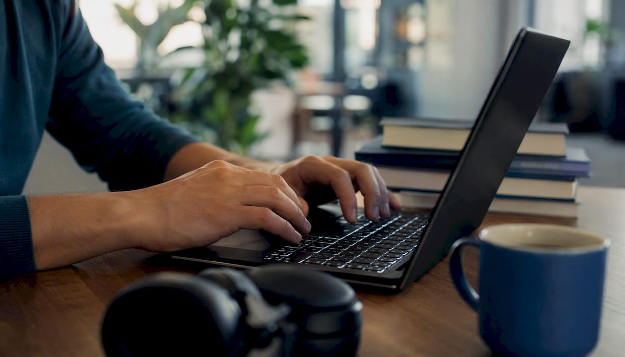 Programmer coding JavaScript on laptop keyboard