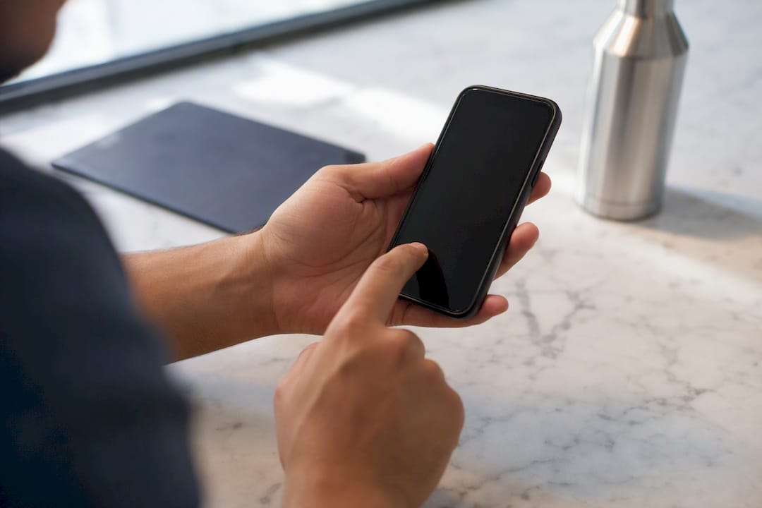 Hand tapping share button on smartphone