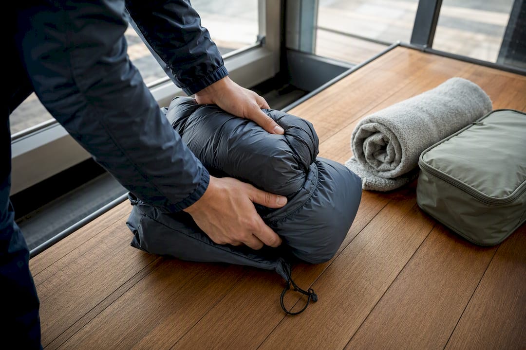 Hands compressing insulated jacket for travel