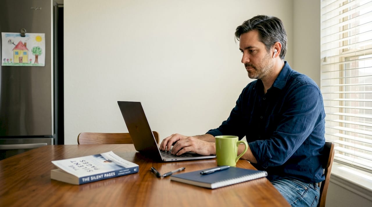 Man at kitchen table during online therapy session