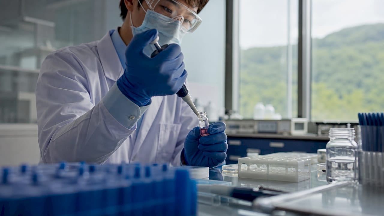 Technician handling stem cell vial in lab