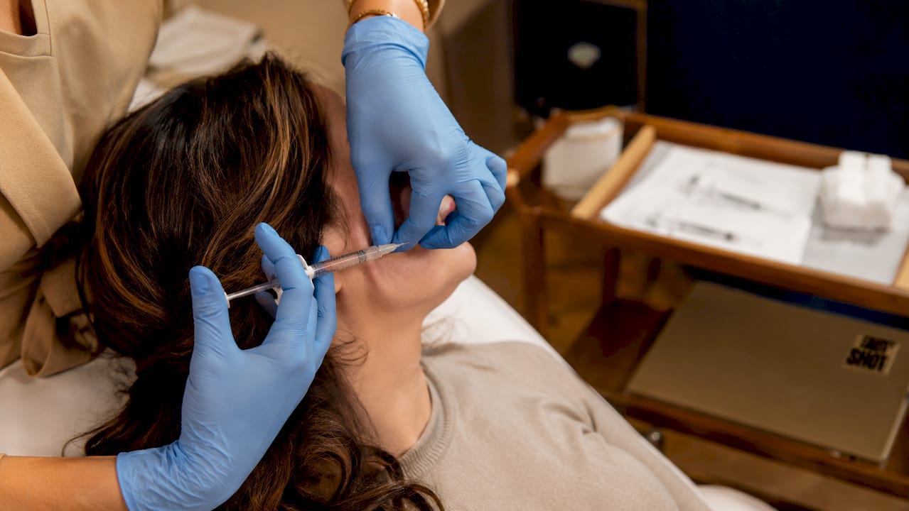 Close-up of hygienic dermal filler injection on cheek