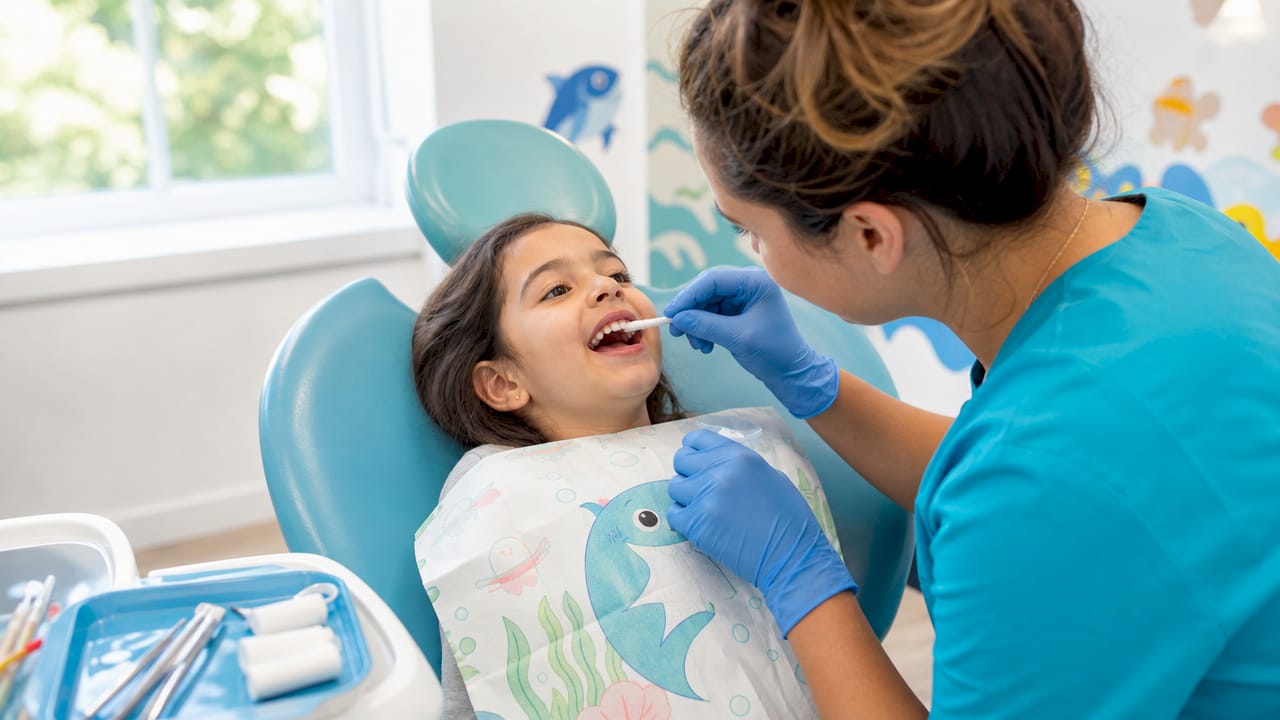Dental hygienist applying fluoride varnish to child