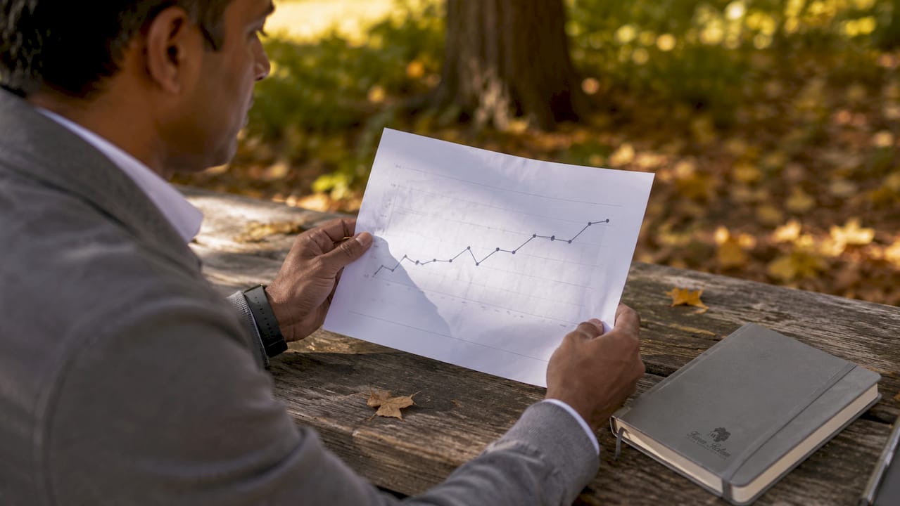 Hands holding Toronto housing price trend graph
