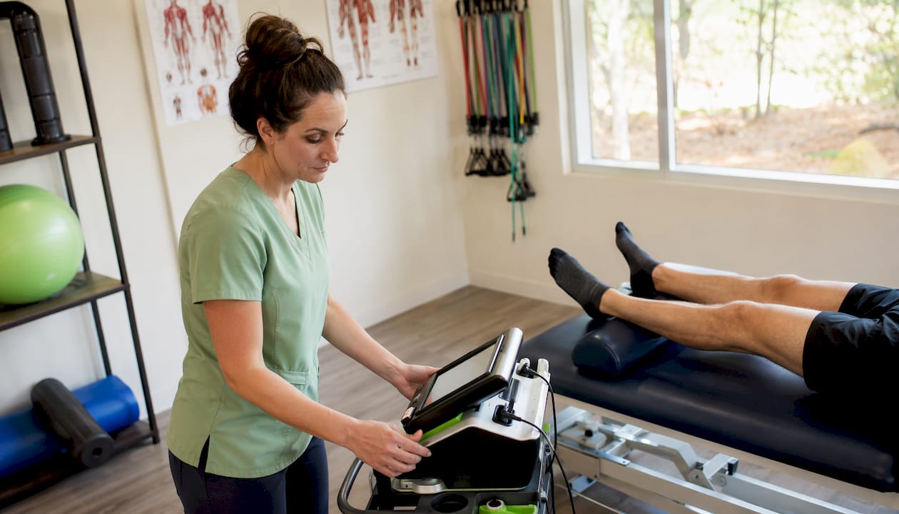 Therapist preparing non-invasive therapy device in clinic