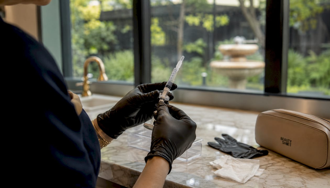Close-up of hands preparing injectable syringe
