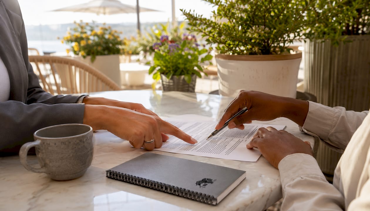 Hands holding title insurance documents on desk