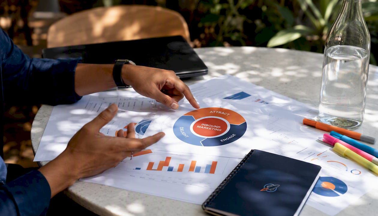 Hands arranging inbound marketing flywheel diagrams on table