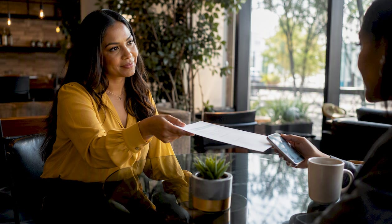 Hands exchanging documents in real estate negotiation