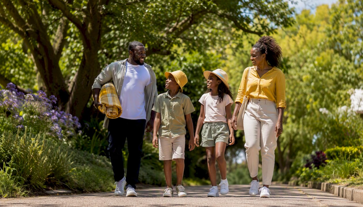 Family walking in sunny neighborhood park