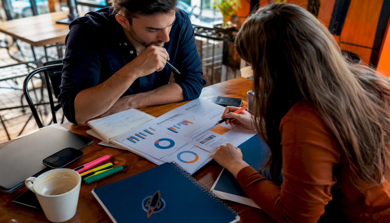 Hands reviewing printed SEO analytics