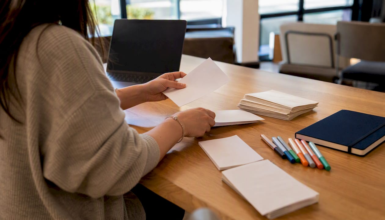 Clinic staff sealing referral program mail envelopes