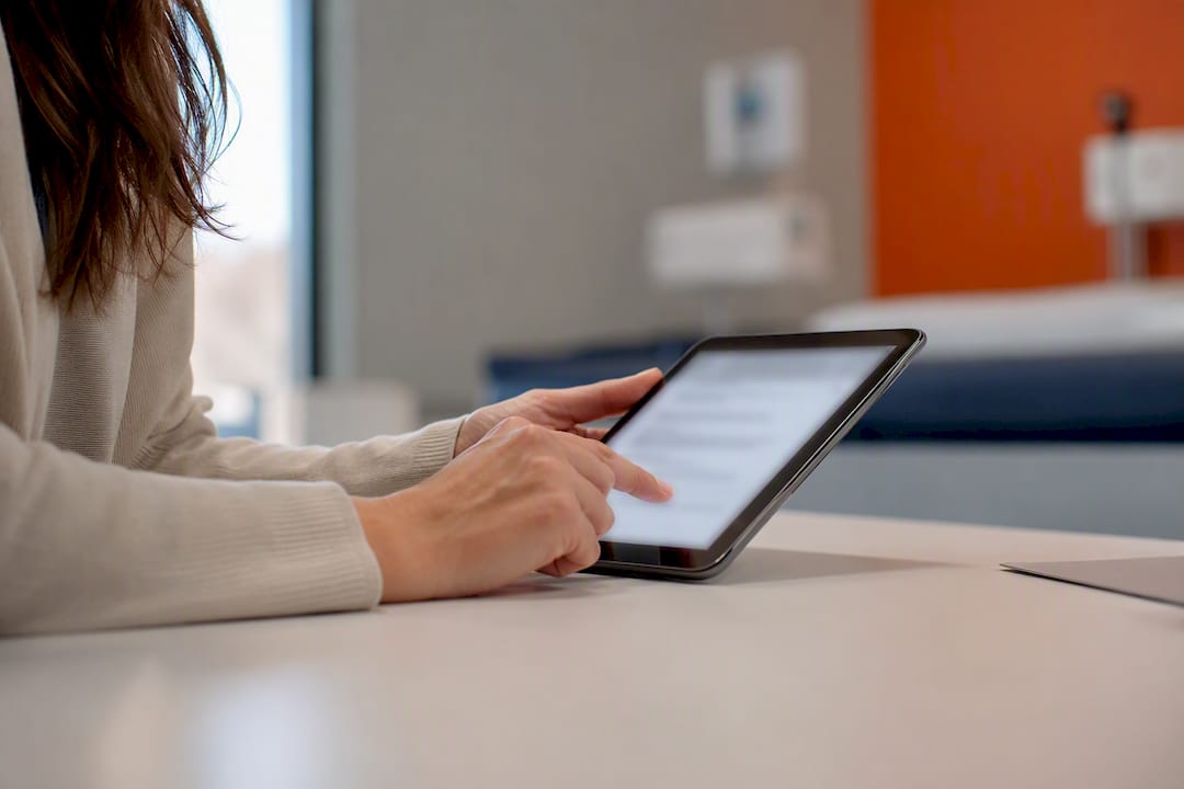 Patient hands signing consent on tablet