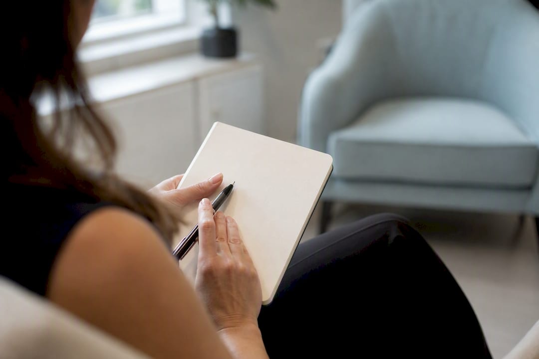 Hand holding blank notebook for jaw clenching notes