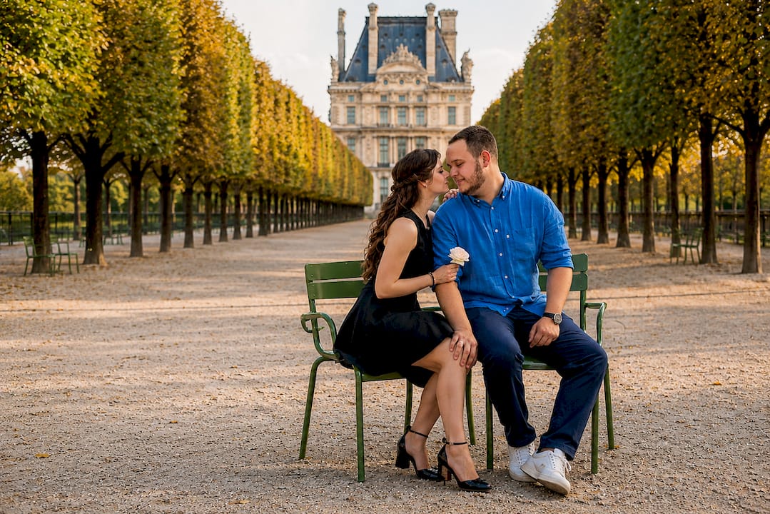 Photographer capturing couple near Arc du Carrousel at sunrise