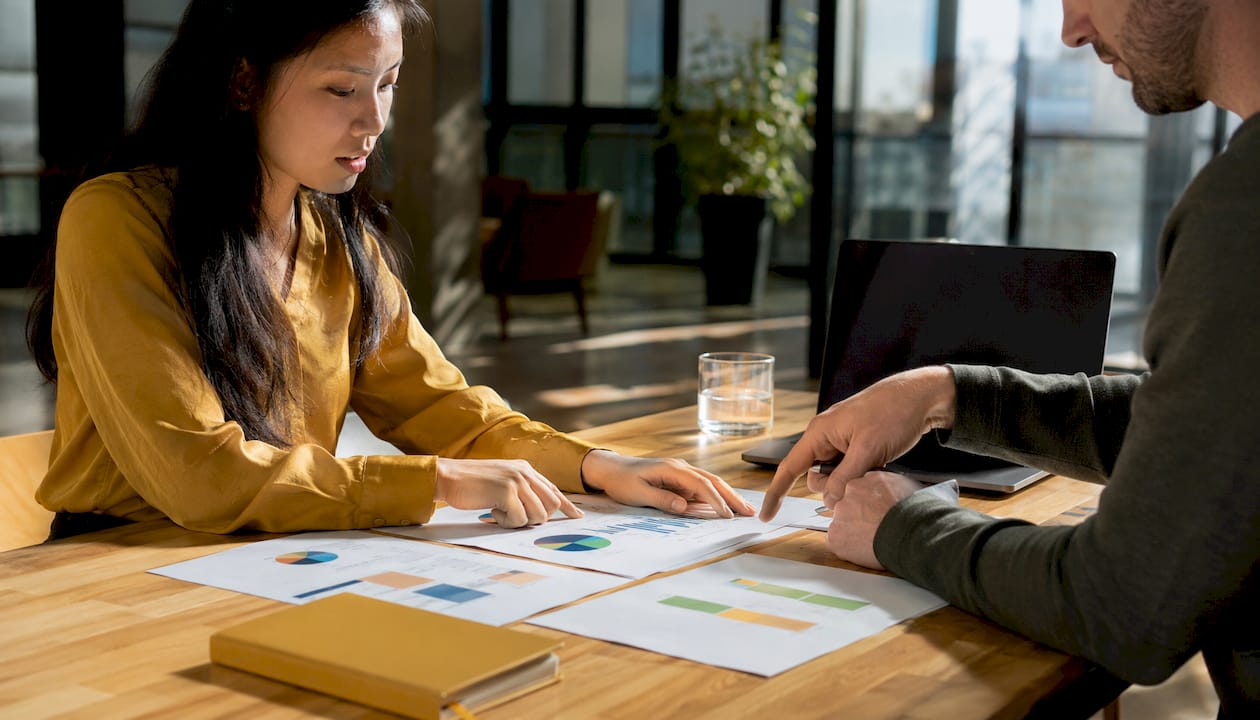 Hands sorting categorized cash flow papers