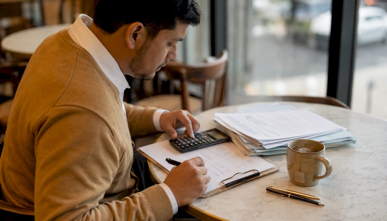 Man calculating cash flow ratios at desk