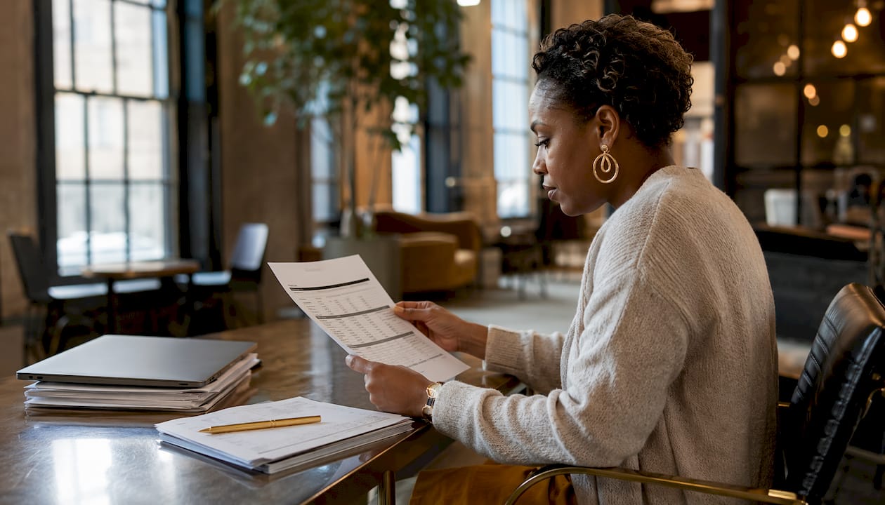 Hands typing next to financial statements on desk