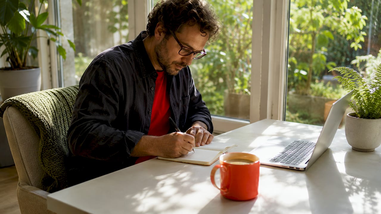 What Is Minimalism Lifestyle? A Guide to Simple Living 2026 Lizard's Lunch Man writing notes in tidy minimalist workspace