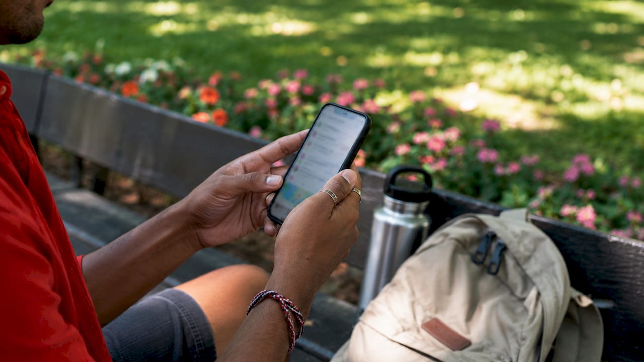 Close-up hands using smartphone travel safety app