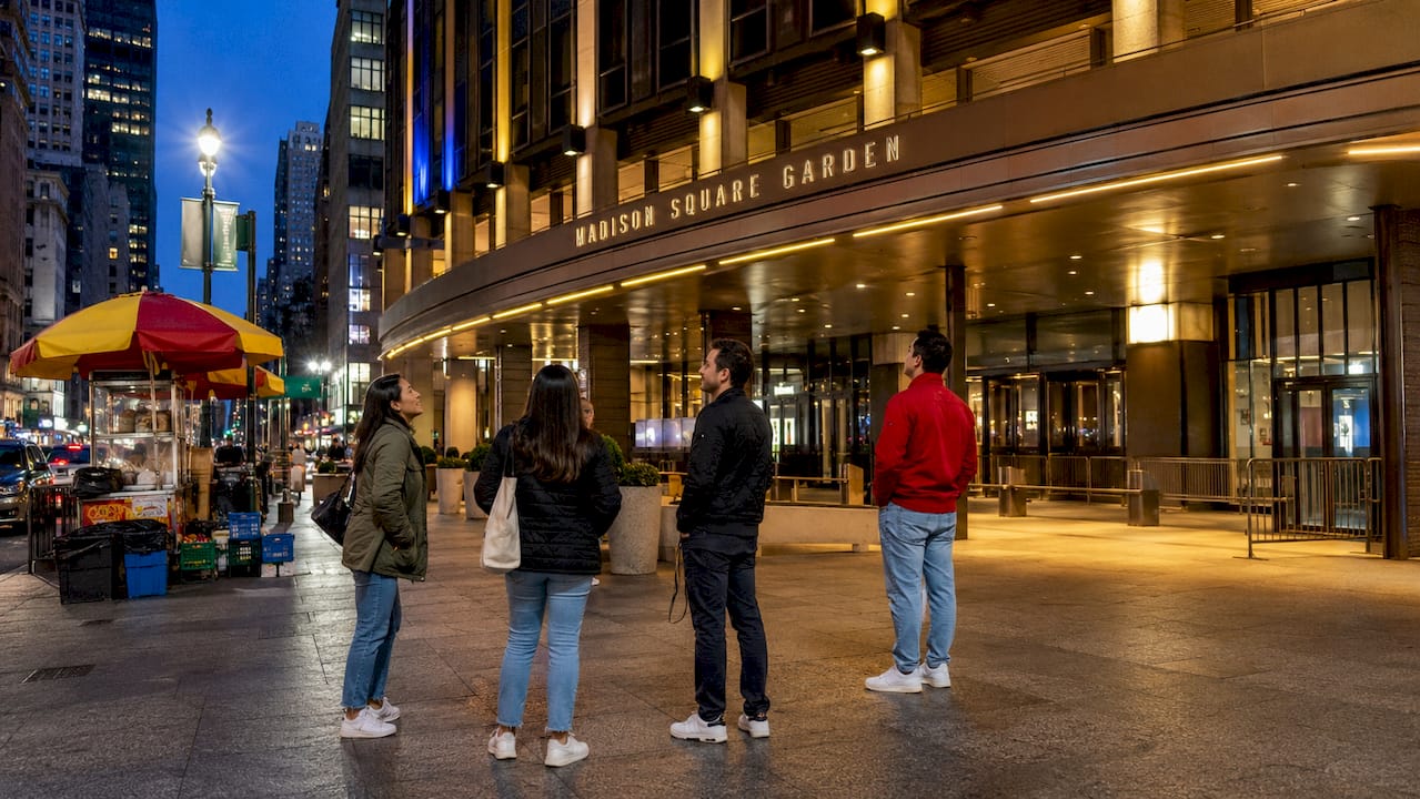 Madison Square Garden exterior at twilight with pedestrians