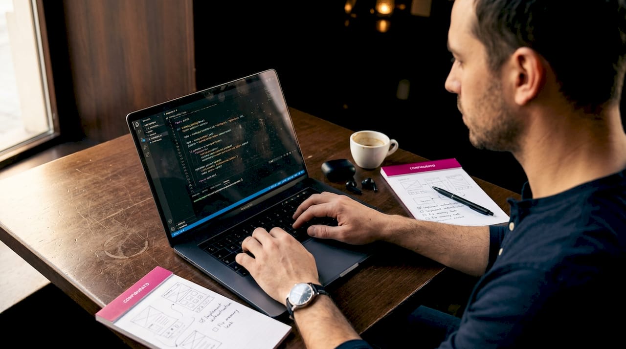 Engineer coding beta product at café table