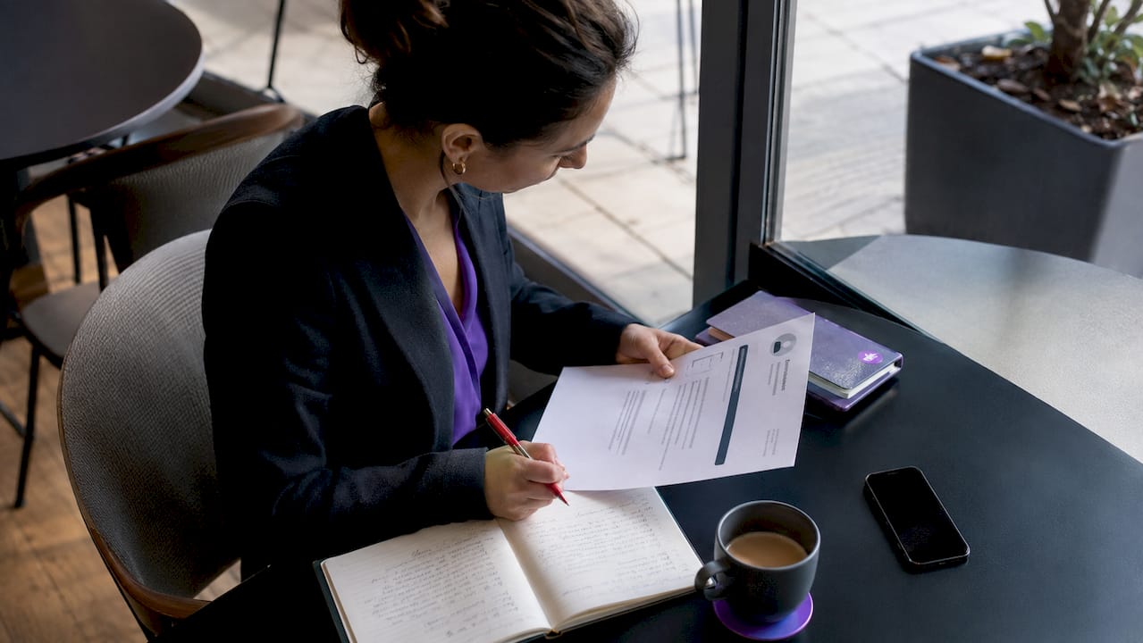 Professional woman reviewing resume documents at home desk