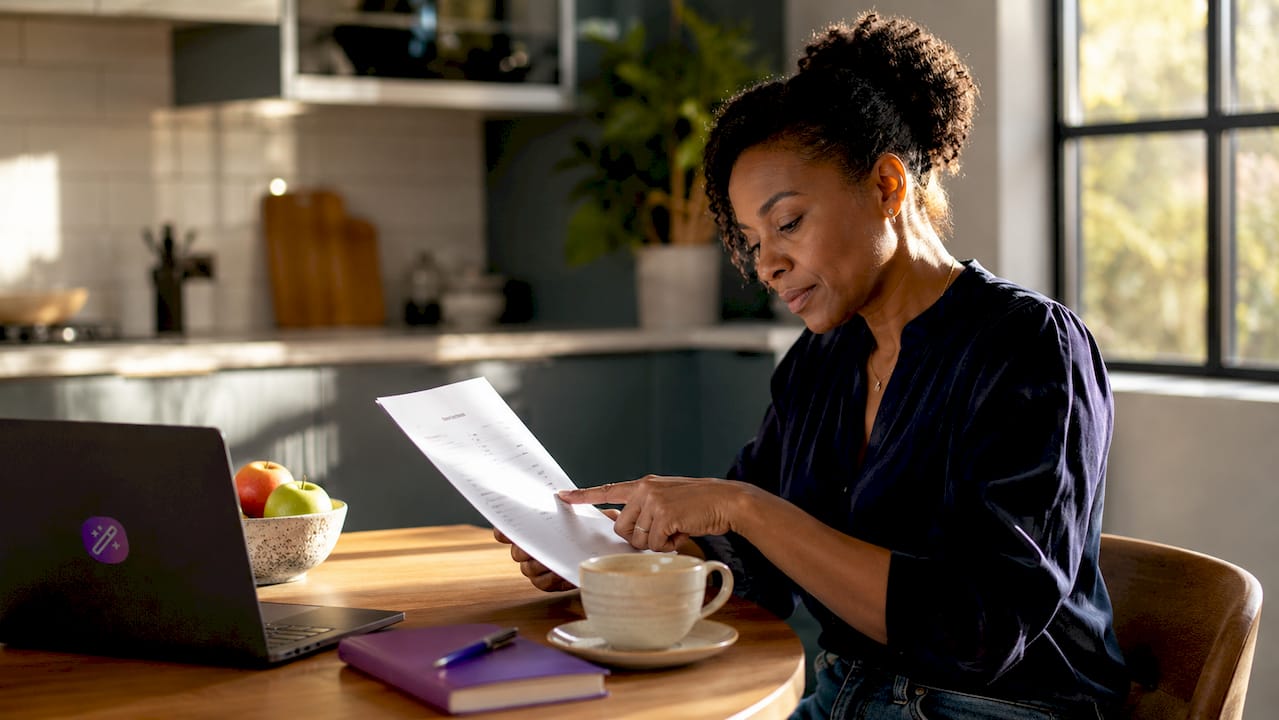 Woman reviewing resume at home office desk