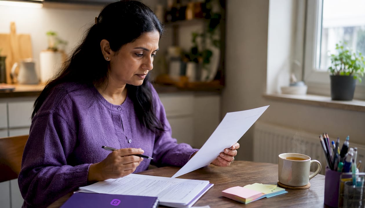 Woman reviewing printed resume at desk