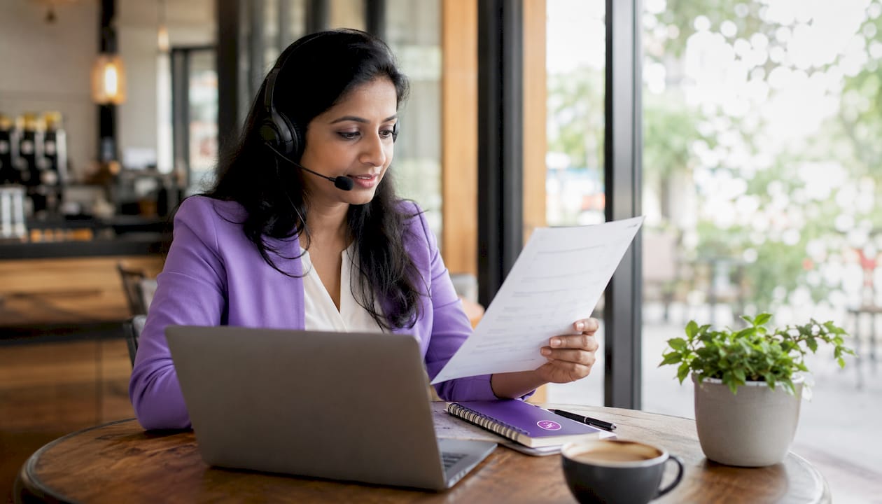Career coach reviewing job list at desk with headset