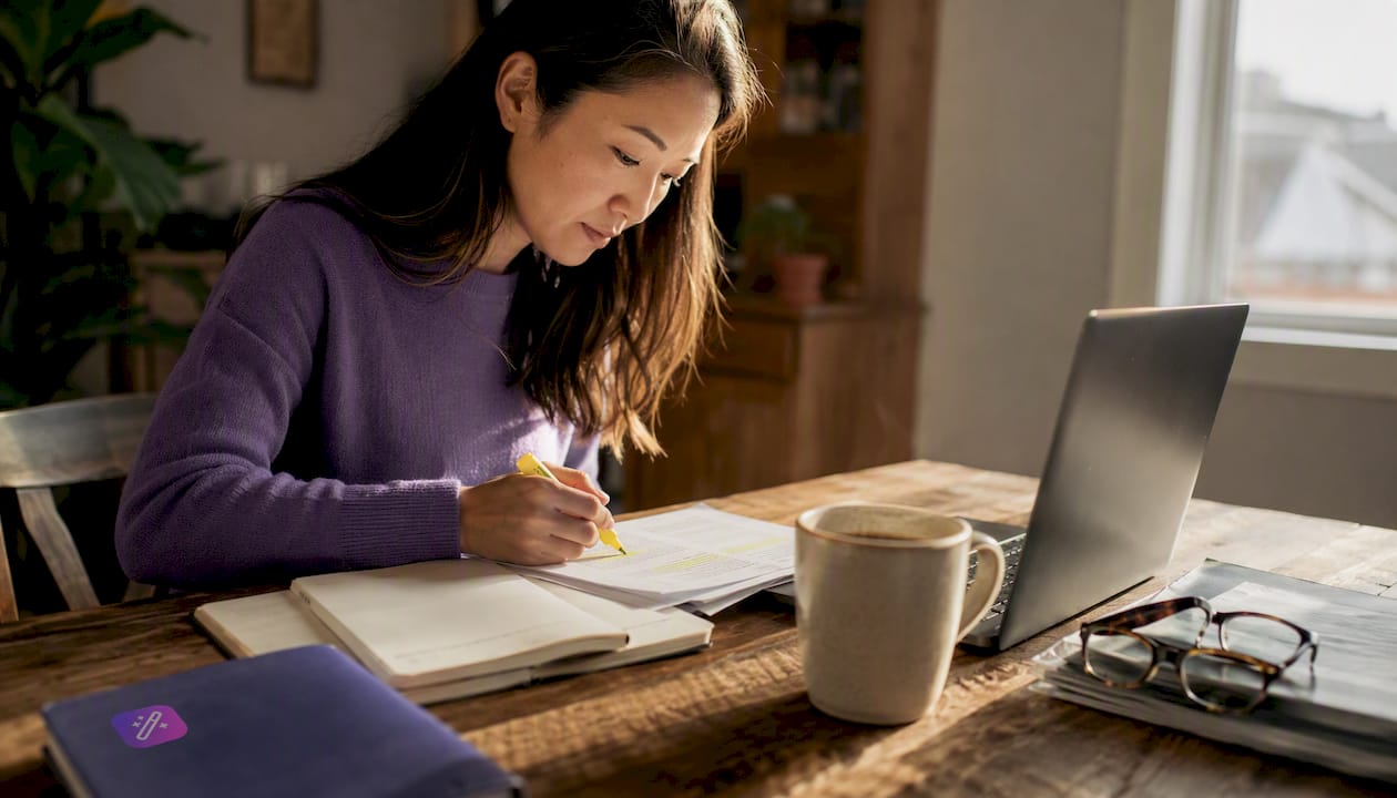 Person highlighting job description at home table