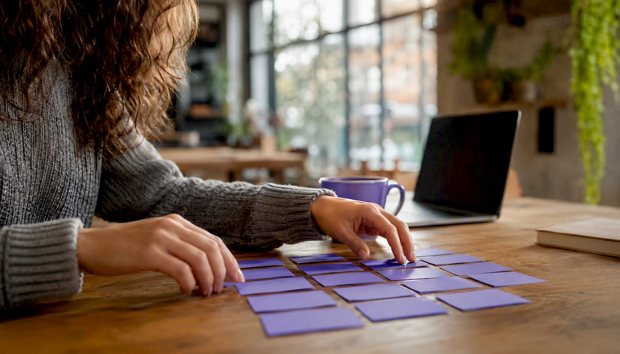 Hands arranging keyword tiles on table for resume scanning