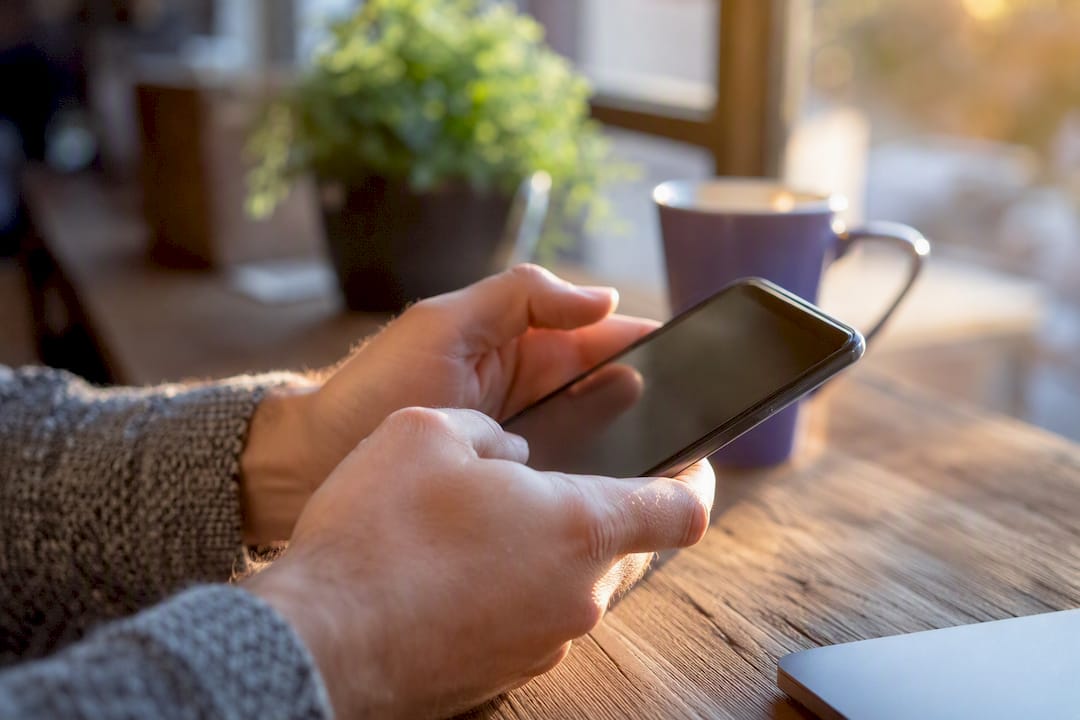 Hands manually testing app on mobile device