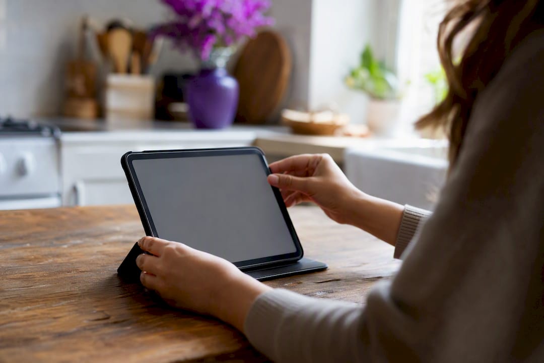 Hands arranging contact info on tablet