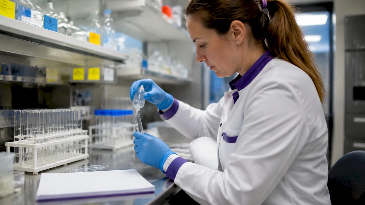 Technician handling gluten test vial in lab